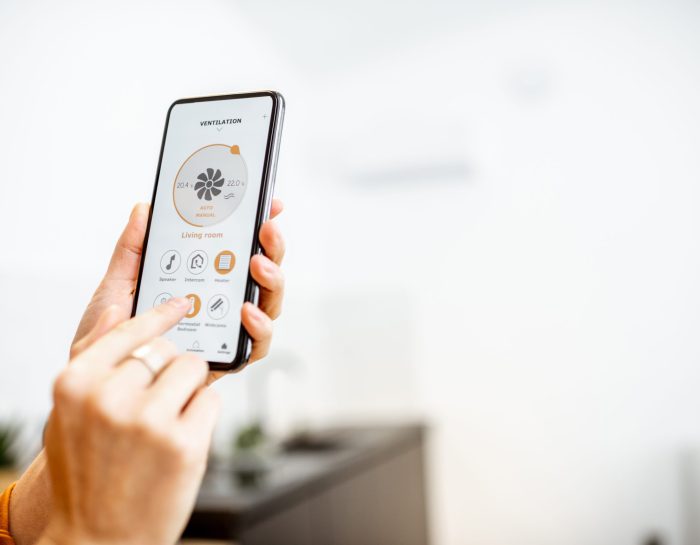 Controlling home ventilation or conditioning with a smart phone, close-up. Concept of a smart home and mobile application for managing smart devices at home